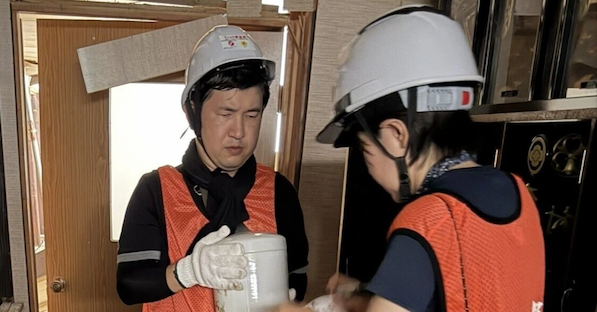 間違えないようにテープに名前を書き、慎重かつ丁寧に遺骨を助け出す支援者＝11日、光現寺