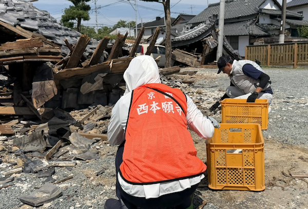 がれきを撤去するボランティアら＝11日、教法寺
