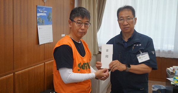 真如苑から支援金を受ける末松市長（右）