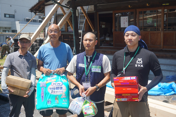物資を受けた鷲峰住職(左から2人目)と支援するスタッフ