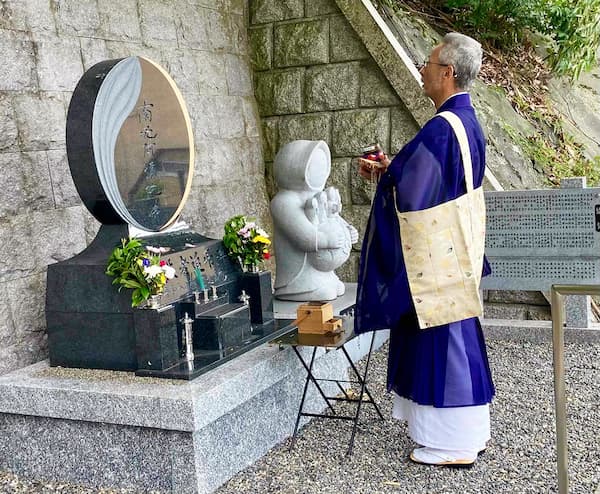 戦没者追弔碑前で法要を営む佐々木住職＝16日、京都市の佛光寺本廟