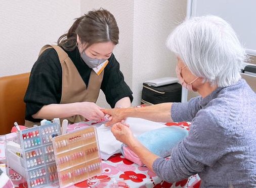 高齢者に福祉ネイルをする醍醐亜希子さん