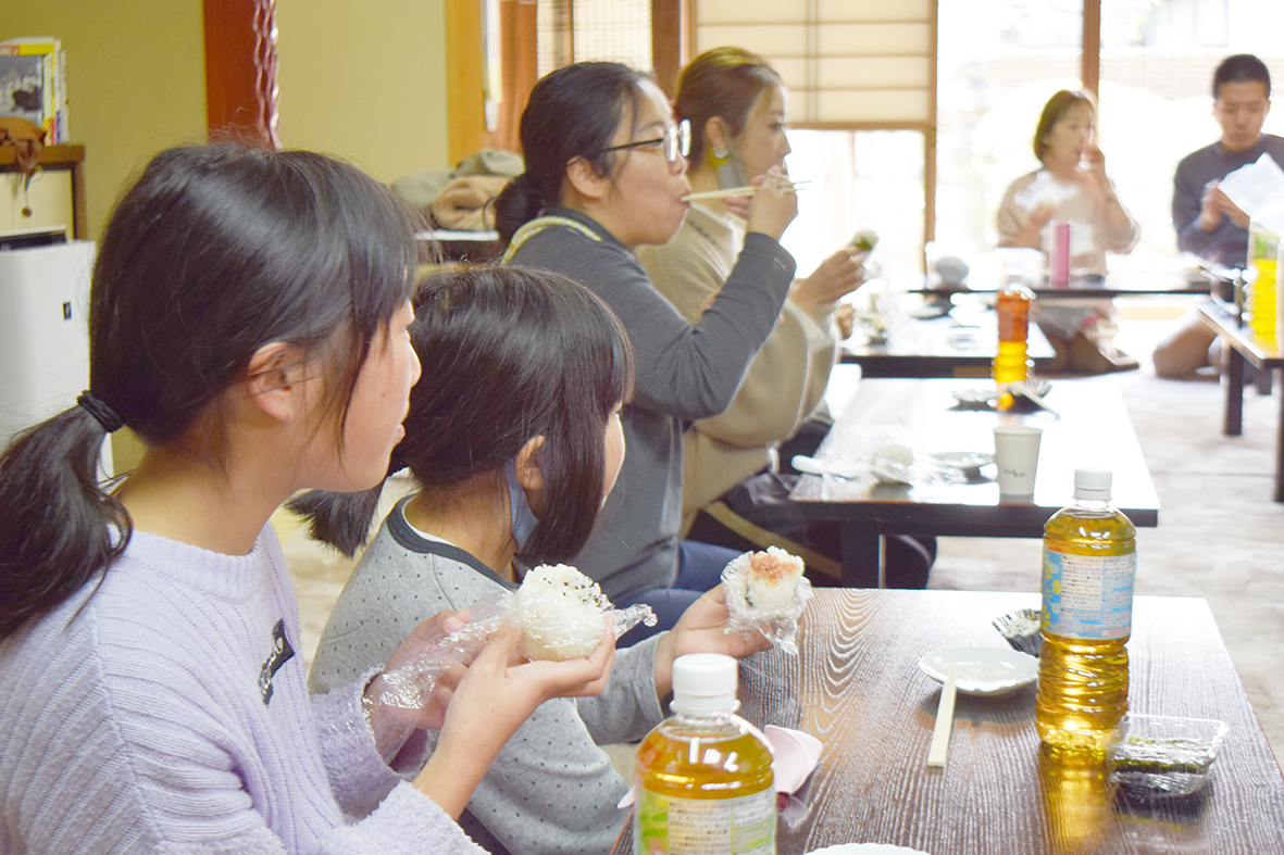 オリジナルのおにぎりを口にする親子ら