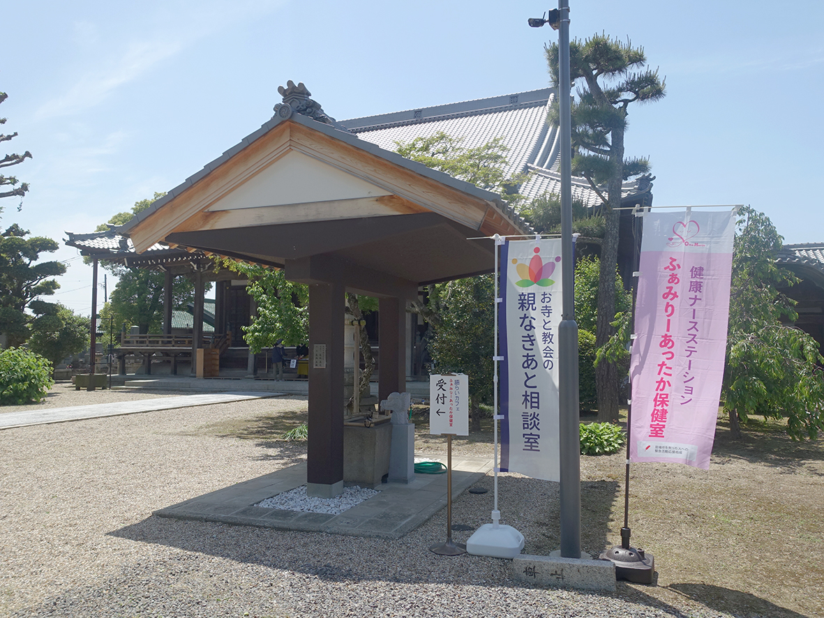 お寺と教会の親なきあと相談室と、ふぁみりーあったか保健室ののぼりが掲げられた境内