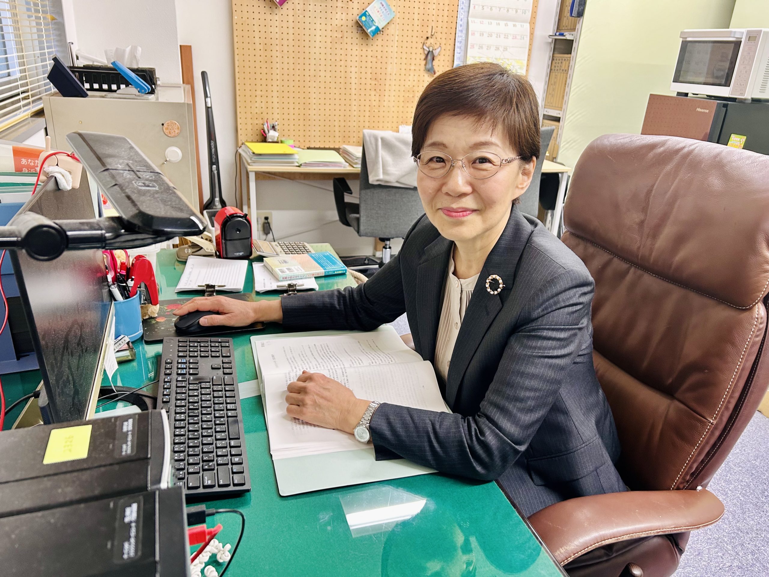 （写真③アイキャッチ兼用：坪井さん　パソコンの前に
キャプ：子どもたちとの出会いで自分自身も成長できたと話す坪井さん）
