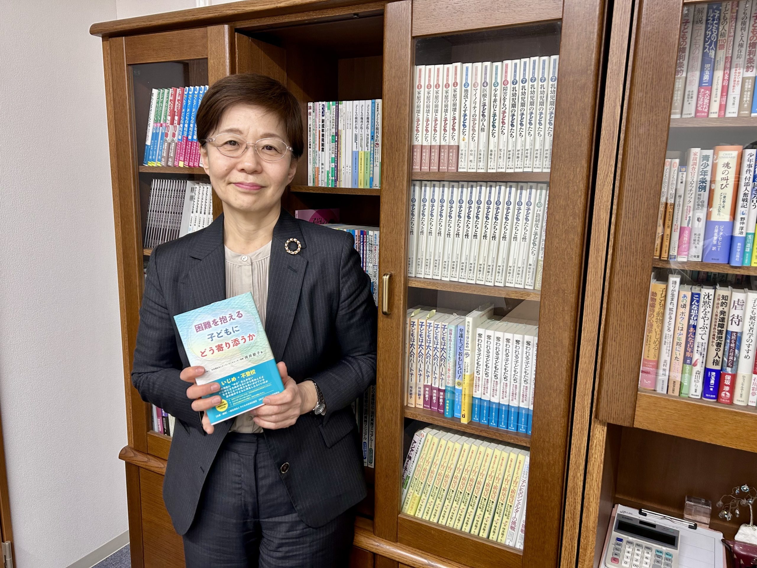 （写真①アイキャッチ兼用：坪井さん　立ち姿
キャプ：　弁護士・社会福祉法人カリヨン子どもセンター理事の坪井節子さん）