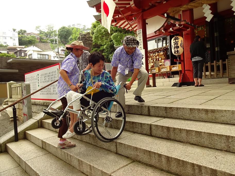 観光名所の來宮（きのみや）神社で車いすに乗る女性を介助する河瀬さん夫妻