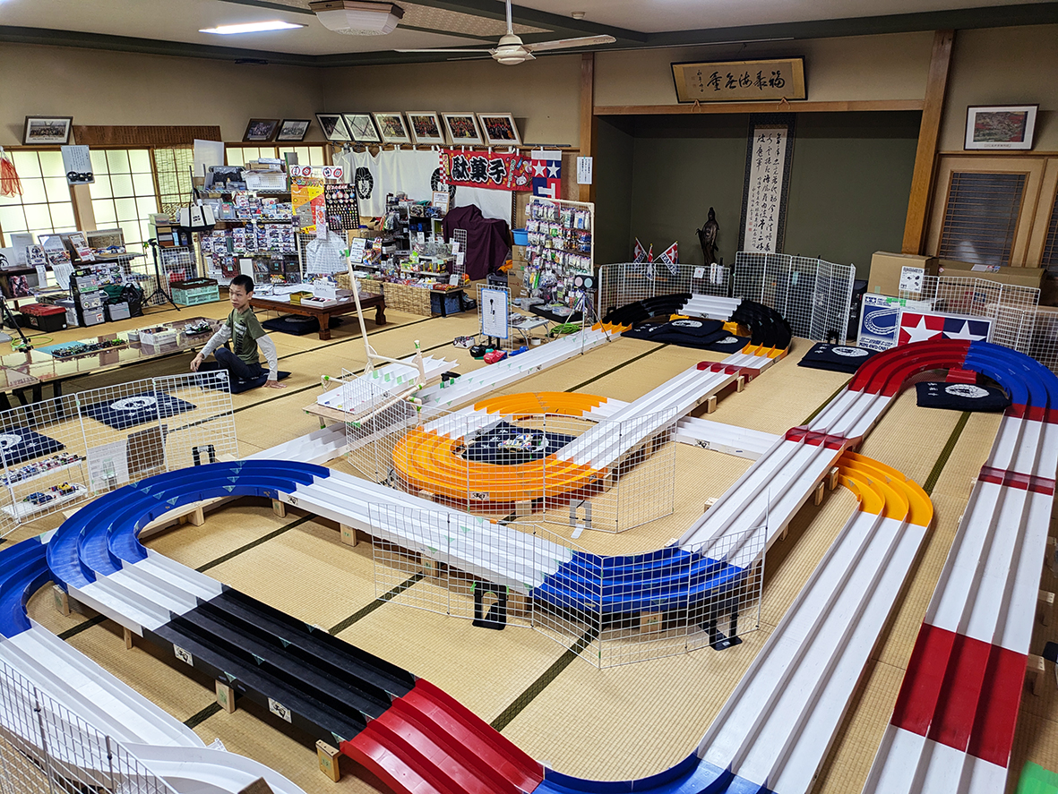 （画像サーキット、アイキャッチ兼用：大広間に常設されたミニ四駆のサーキット。奥には工作体験コーナーも）