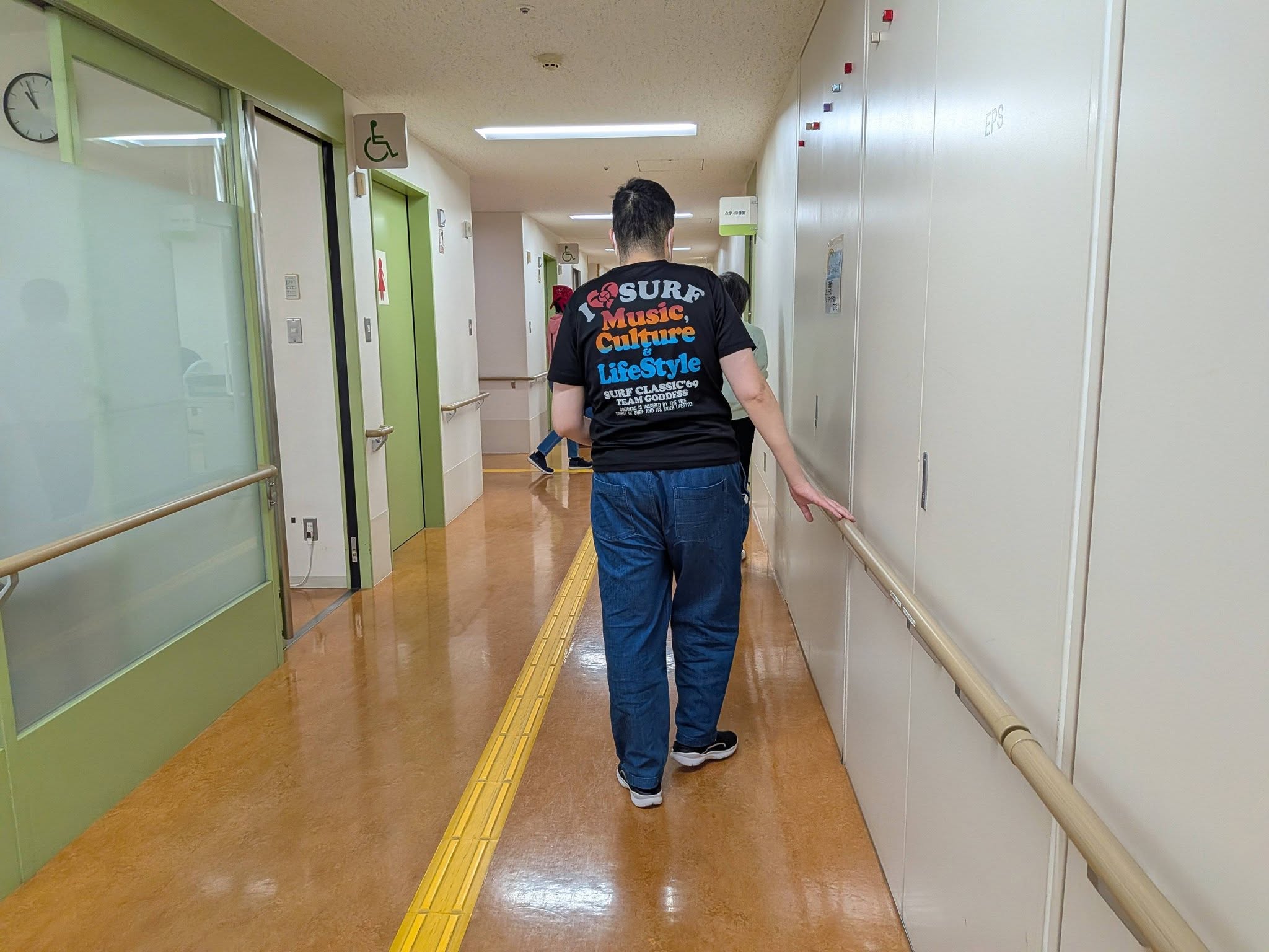 手すりに触れながら廊下を移動する利用者